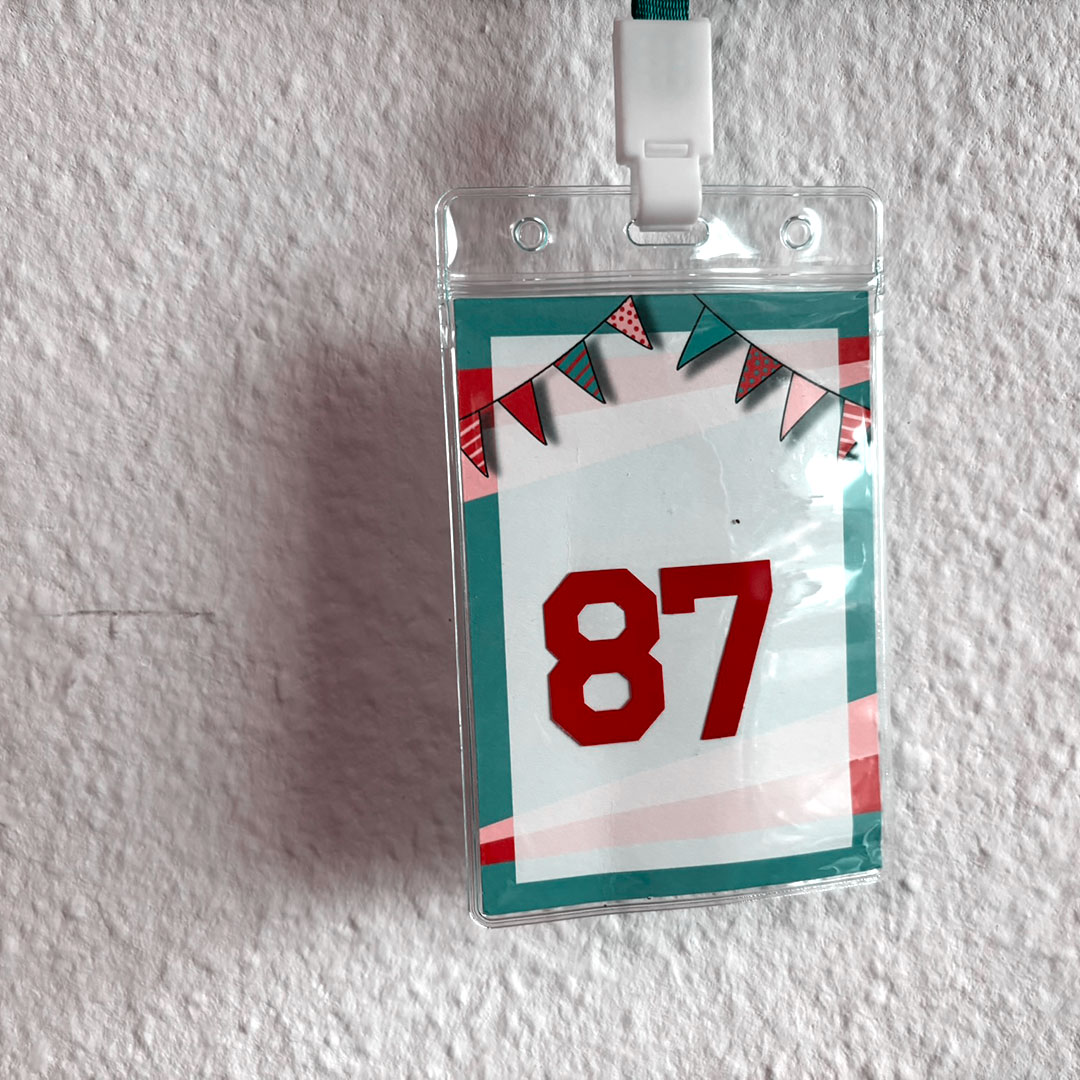Umhängeschild mit der roten Zahl 87 als Symbol für den Abiturjahrgang 1987
